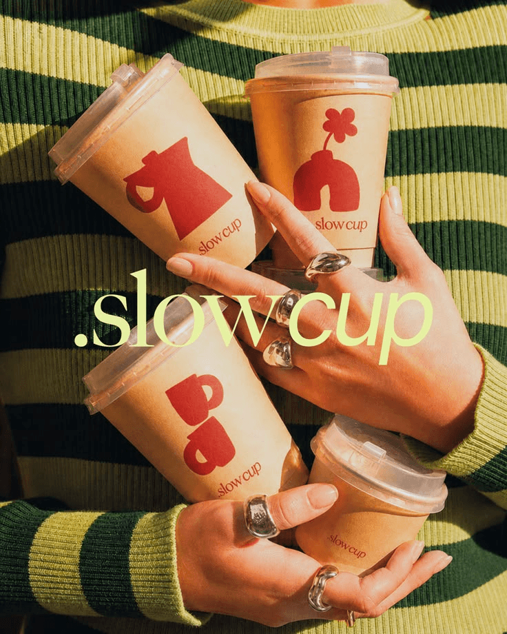 Hands holding Slow Cup takeaway coffees